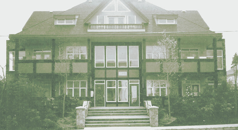 Front elevation photograph highlighting the dramatic central entrance and timber detailing of Le Mansion Condominium.